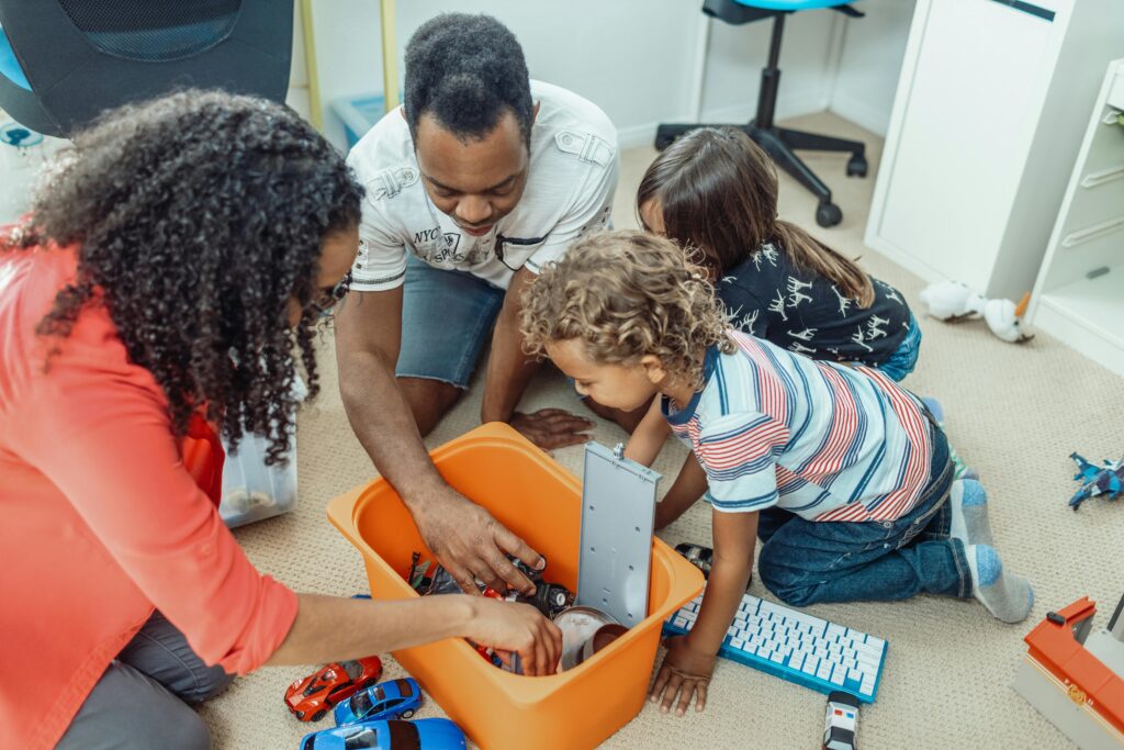 A multicultural family enjoying playtime together with toys indoors, fostering love and joy.